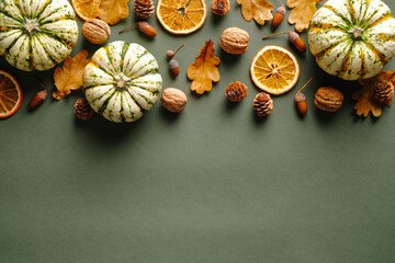 Obraz na płótnie Canvas Autumn composition. Flat lay pumpkins, fallen oak leaves, dry oranges, acorns on vintage green background. Thanksgiving day greeting card design.