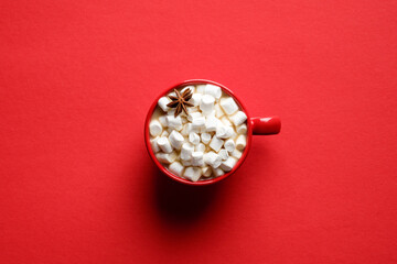 Cup of hot cocoa with marshmallows on red background. Flat lay, top view.