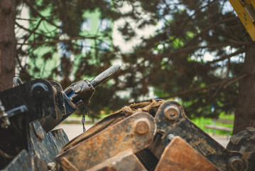 Close-up shot of the pneumatic jackhammer and buckets for the excavator lying on the ground at the demolition site. 