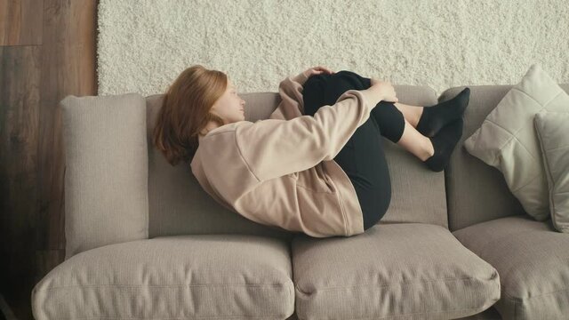 View From Above. A Pensive Red-haired Girl is Sad Alone at Home. A Depressed Teenager Suffers From Loneliness, Lack of Communication, Lack of Friends. Mental Health.