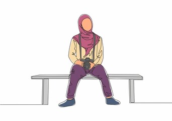 Single continuous line drawing of young cute muslimah sitting on chair while carrying dslr camera. Beautiful Asian woman model in trendy hijab fashion concept one line draw design vector illustration