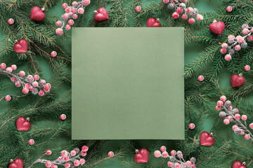 Green red Christmas background with square copy-space, place for text. Natural Xmas twigs decorated...