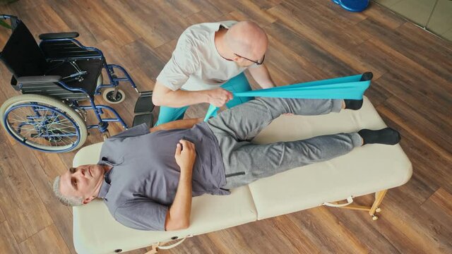 A Man With a Brain Stroke Undergoes a Health Recovery Therapy Session with the Help of a Physiotherapist in a Rehabilitation Center. Sports Physiotherapy Concept. Brain Hemorrhage.