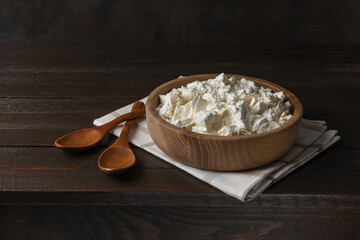 Cottage curd cheese in a bowl on old wooden table.