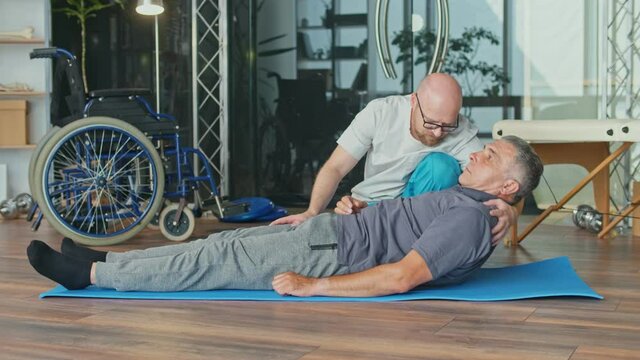 Physiotherapist Conducting a Rehabilitation Session For a Man with a Brain Stroke. Recovery in a Rehabilitation Center, Improving the Quality of Life of a Person with a Disability.