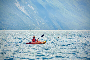 A woman who's having fun in a canoe on the Garda Lake
