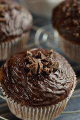 Chocolate muffin with dark chocolate coating, arranged on cake rack.