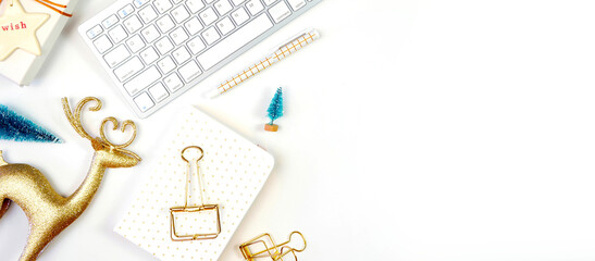 Christmas holiday framed border banner. Christmas shopping desktop in modern gold and white theme with reindeer decoration, keyboard, gift and desktop accessories. Top view blog hero header. © millefloreimages