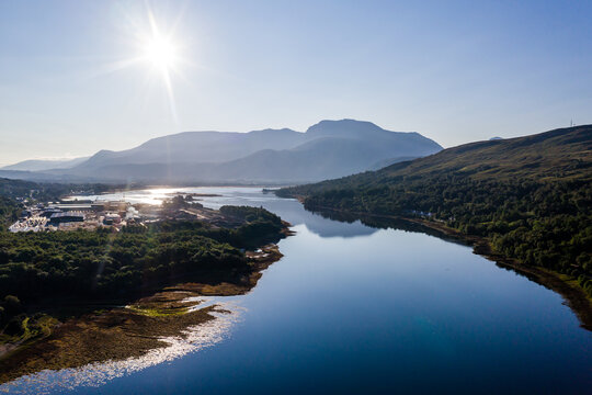 Aerial view of the sun rising above Fort William and the Ben Nevis mountain range in the Scottish Highlands
