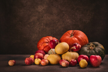 Autumn harvest, happy Thanksgiving day, Halloween. Festive still life with pumpkins and apples on dark  brown background with copy space.