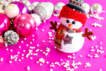 Christmas snowman in christmas decoration with pink background