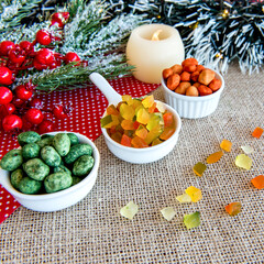 Obraz na płótnie Canvas Colorful peanuts and colorful candied fruit on a Christmas table