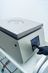 Medical laboratory worker using centrifuge machine in clinic