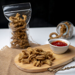 Close up view of kripik usus ayam or gut chicken fried snack fritters crackers. traditional menu from Indonesia, in the plastic packaging