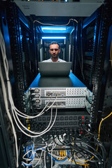 Caucasian data center technician doing security maintenance of server