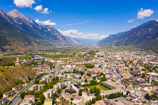 Aerial view of Martigny modern cityscape in Rhone Valley at foot of Swiss Alps in sunny summer day, canton of Valais