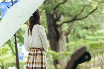 新緑の風に吹かれる女性　
公園で待ち合わせをする女性　
傘をさす女性