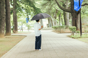 新緑の風に吹かれる男性　
公園で待ち合わせをする男性　
傘をさす男性
