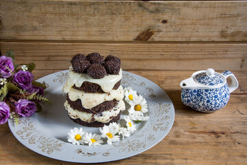 Chocolate cake with flowers and a blue kettle around