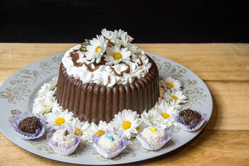 chocolate truffle cake with flowers and candy around