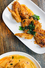 top down of deep fried thai chicken wings with garlic, chili paste, and fish sauce