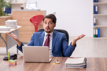 Young male employee sitting at workplace