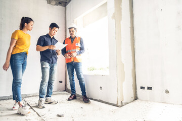 Young asian couple checking house with foreman engineering home inspection building house Walk home inspection with looking construction for check building home on job site to construction 2021