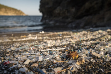 Small plastic parts and microplastics on the sand beach