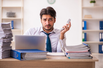 Young businessman employee unhappy with excessive work in the office