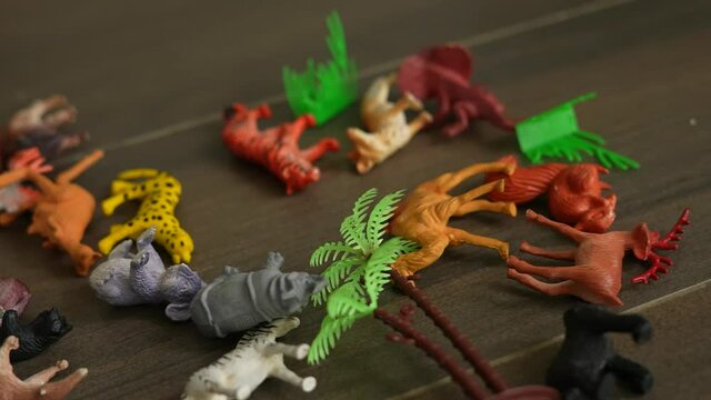 collection of plastic jungle animal toys for kids on the floor with zebra bear and kangaroo scattered on the floor