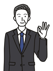 オッケーポーズのスーツを着たシニア男性