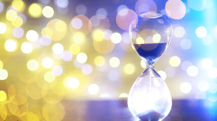 Hourglass and Christmas background. Christmas, new year, copy space, bokeh.