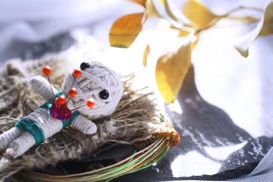 Voodoo Doll on a stone background with dramatic lighting. Mystic still life with voodoo doll and witchcraft objects.