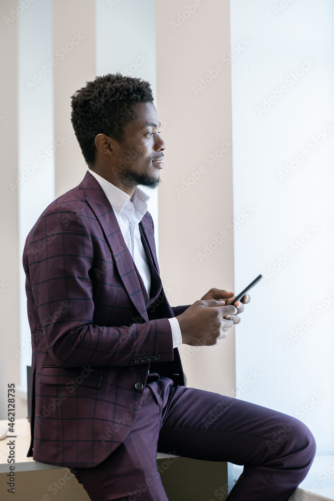 Poster distracted african businessman in suit scrolling in smartphone in front of camera