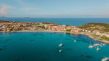 Obraz premium the picturesque coastal village of Golfo Aranci in northern Sardinia. perfect for vacations, beautiful beaches, clear blue water. Boats and yachts anchored on the jetty. drone aerial view Italy.