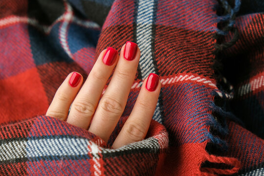 Stylish red female nails. Modern Beautiful manicure. Autumn winter nail design concept of beauty treatment. Gel nails. Skin care.