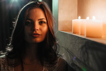Aromatherapy. A sexy brunette in underwear extinguishes candles before bedtime. Romantic setting on...