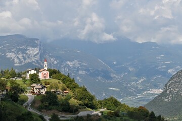 La Guardia frazione di Folgaria in Trentino chiesa illuminata dal sole sfobndo delle Dolomiti di Brenta