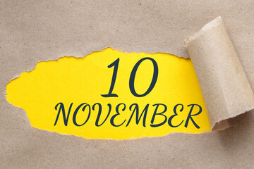 november 10. 10th day of the month, calendar date.Hole in paper with edges torn off. Yellow background is visible through ragged hole.Autumn month, day of the year concept