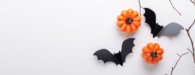 Horizontal Halloween banner. Black paper bats and pumpkins on white background. Top view, copy space