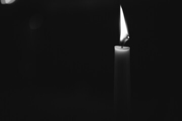 Grayscale of a burning candle isolated on a dark background