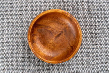 Wooden empty bowl on a jute gray burlap