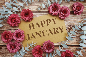 Happy January typography text on paper card decorate with flower on wooden background