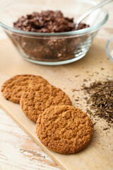 Wooden board with tasty hojicha cookies on white wooden background