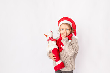 little girl in a Santa hat with a snowman on a white background, space for text