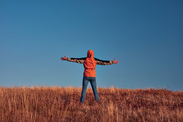 Man with arms wide open enjoying on a mountain hill top.