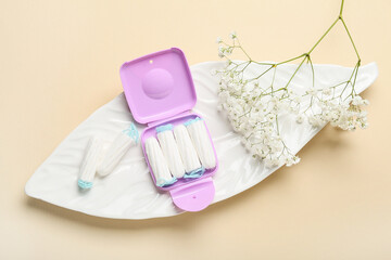 Tampons storage box and gentle white flowers on beige background