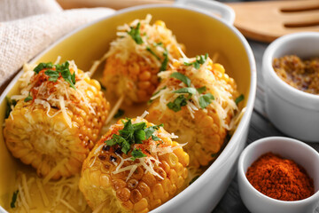 Baking dish with pieces of delicious Elote Mexican Street Corn on table, closeup