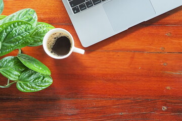 Coffee and laptop on wooden desk.