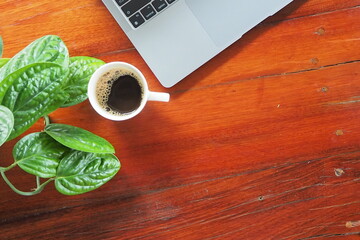 Coffee and laptop on wooden desk.
